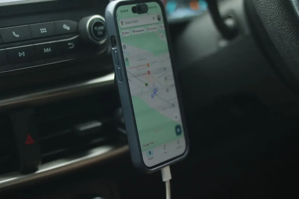 Smartphone met navigatie-app en kaart in een houder op het dashboard van een auto