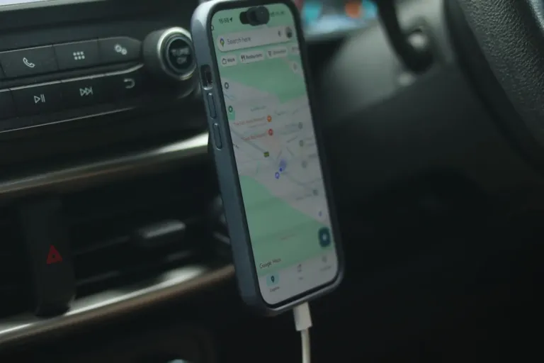 Smartphone met navigatie-app en kaart in een houder op het dashboard van een auto