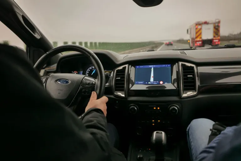 Bestuurder op de snelweg met een navigatiescherm in het dashboard van de auto