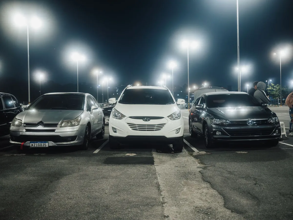 Geparkeerde auto's op een verlichte parkeerplaats in de avond